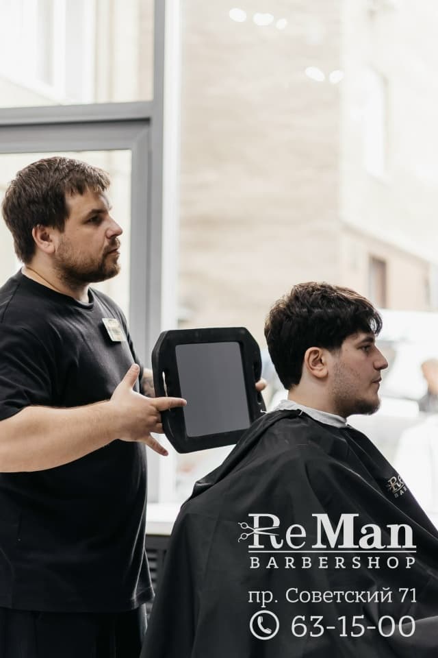 Барбер показывает результат стрижки